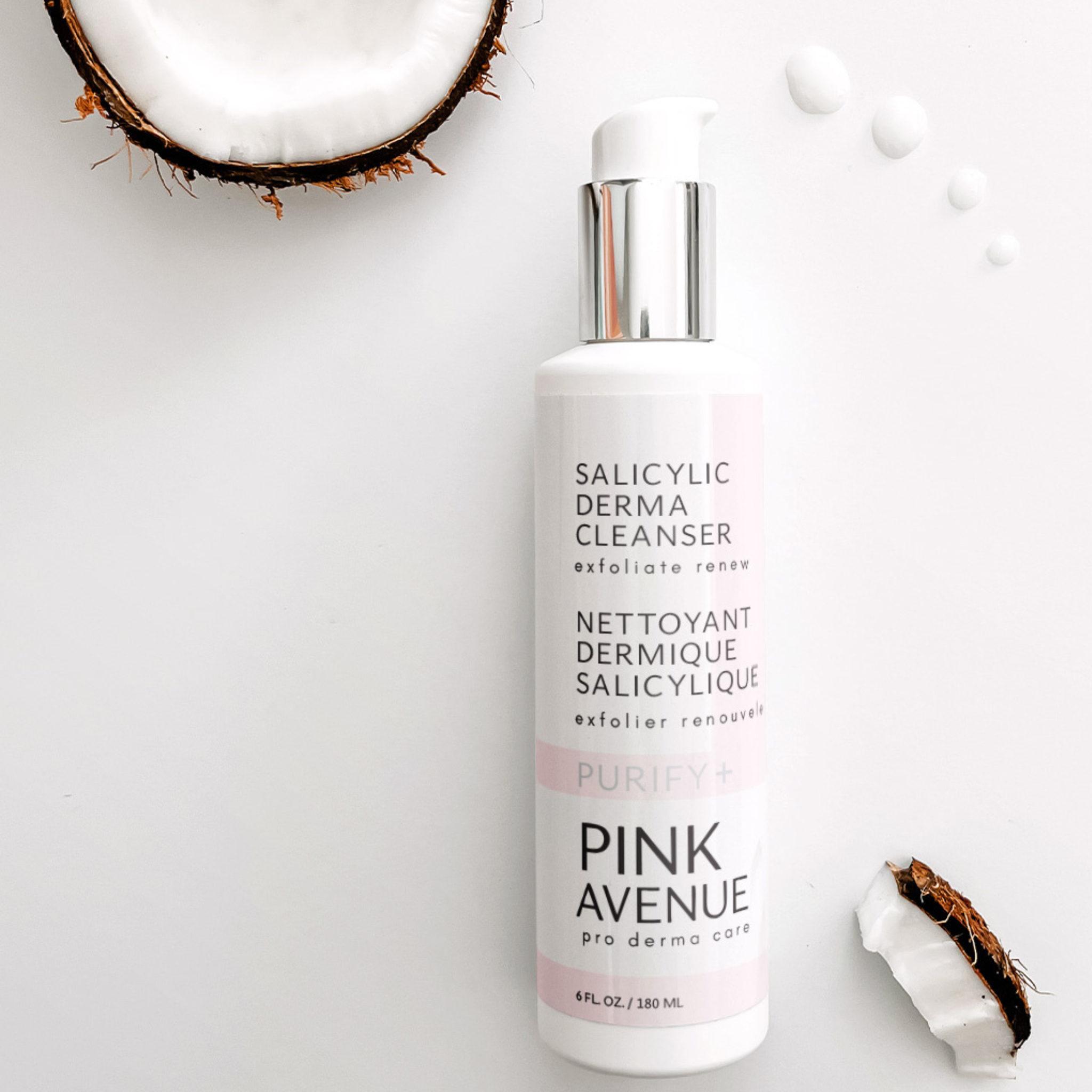 Pink Avenue Salicylic derma cleanser bottle with coconut pieces on a light background