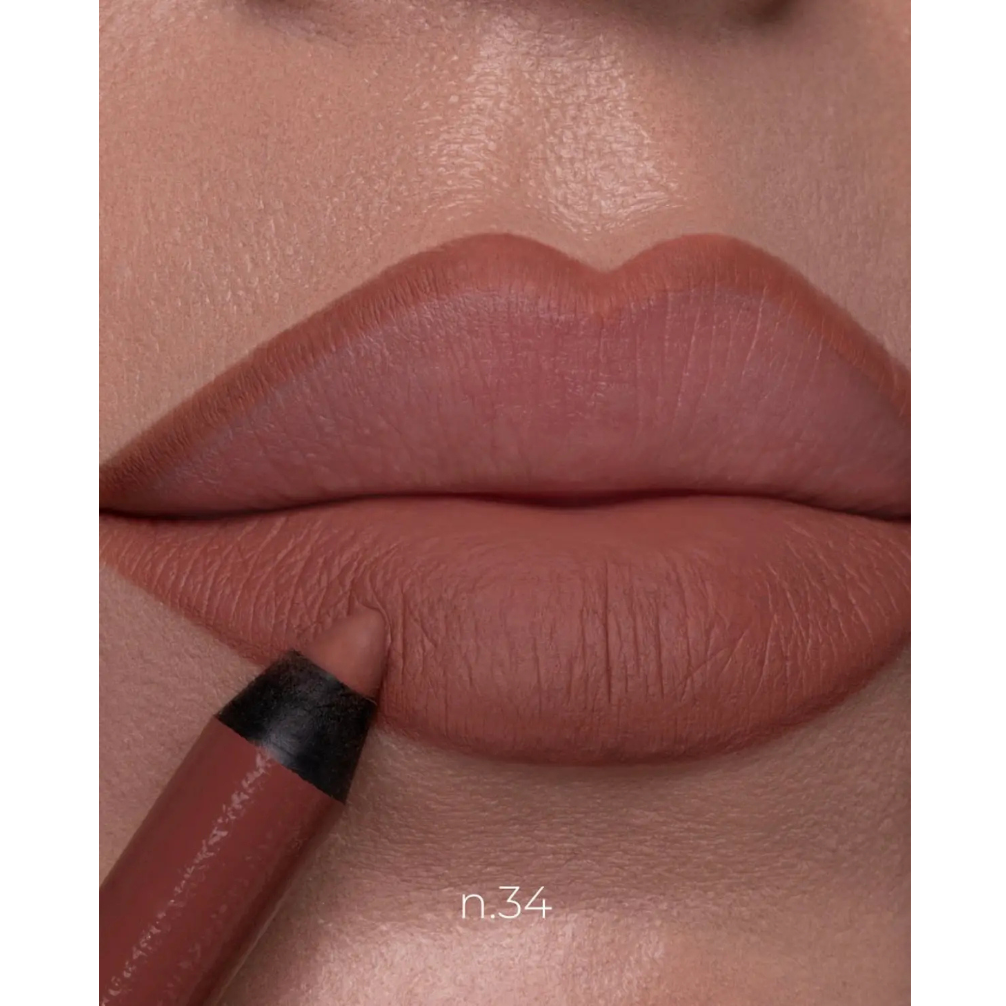 Close-up of a person's lips wearing a matte dusty rose lip color, with a matching lip pencil touching the lower lip. The shade is labeled 'n.