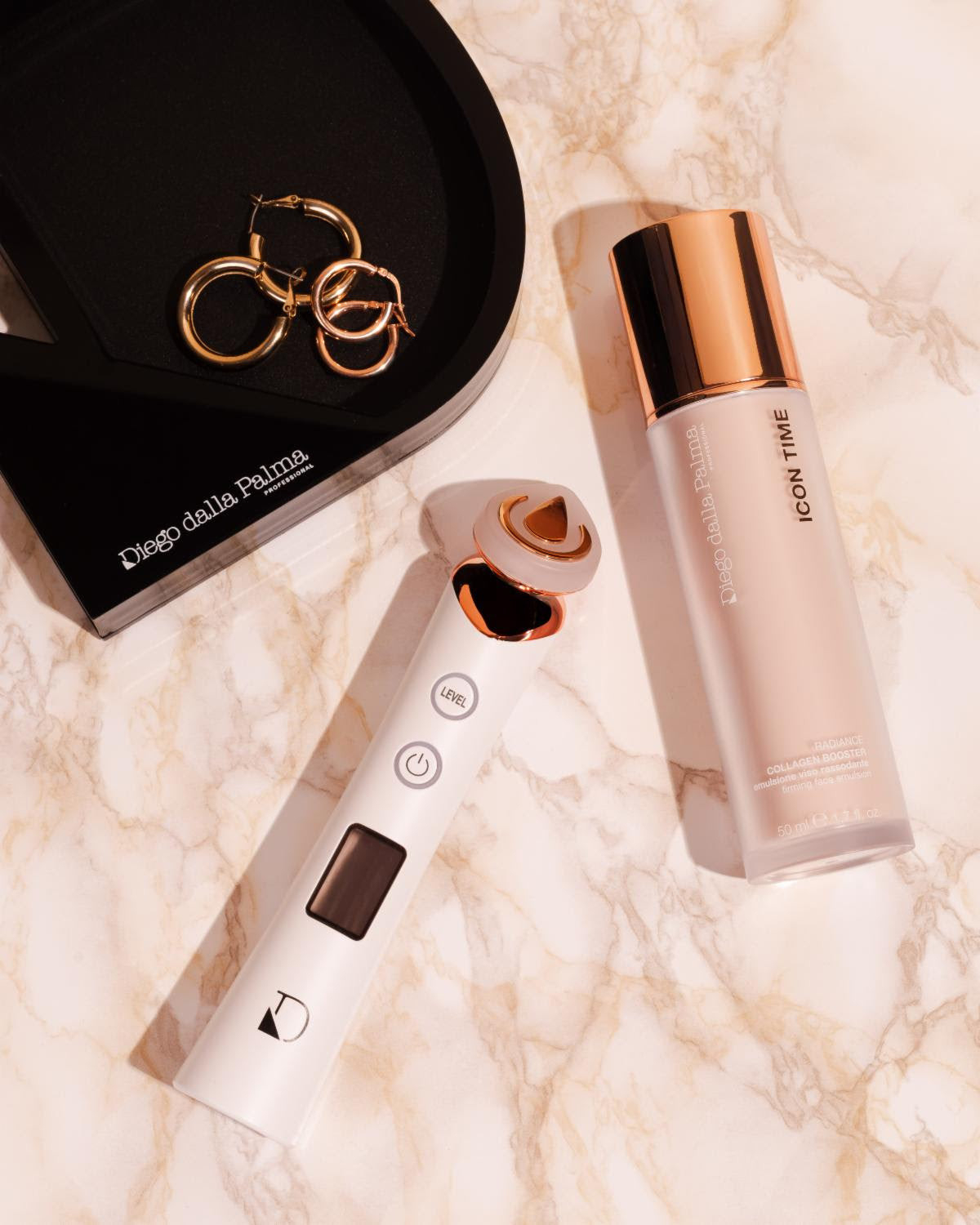 Beauty device and skincare bottle on a marble surface with 'Diego Dalla Palma' branding.