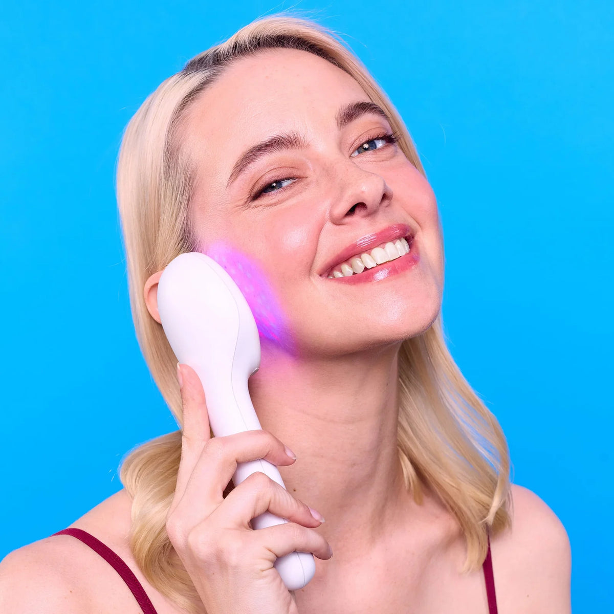 Woman using LightStim for Acne LED device on her cheek Gen 3 