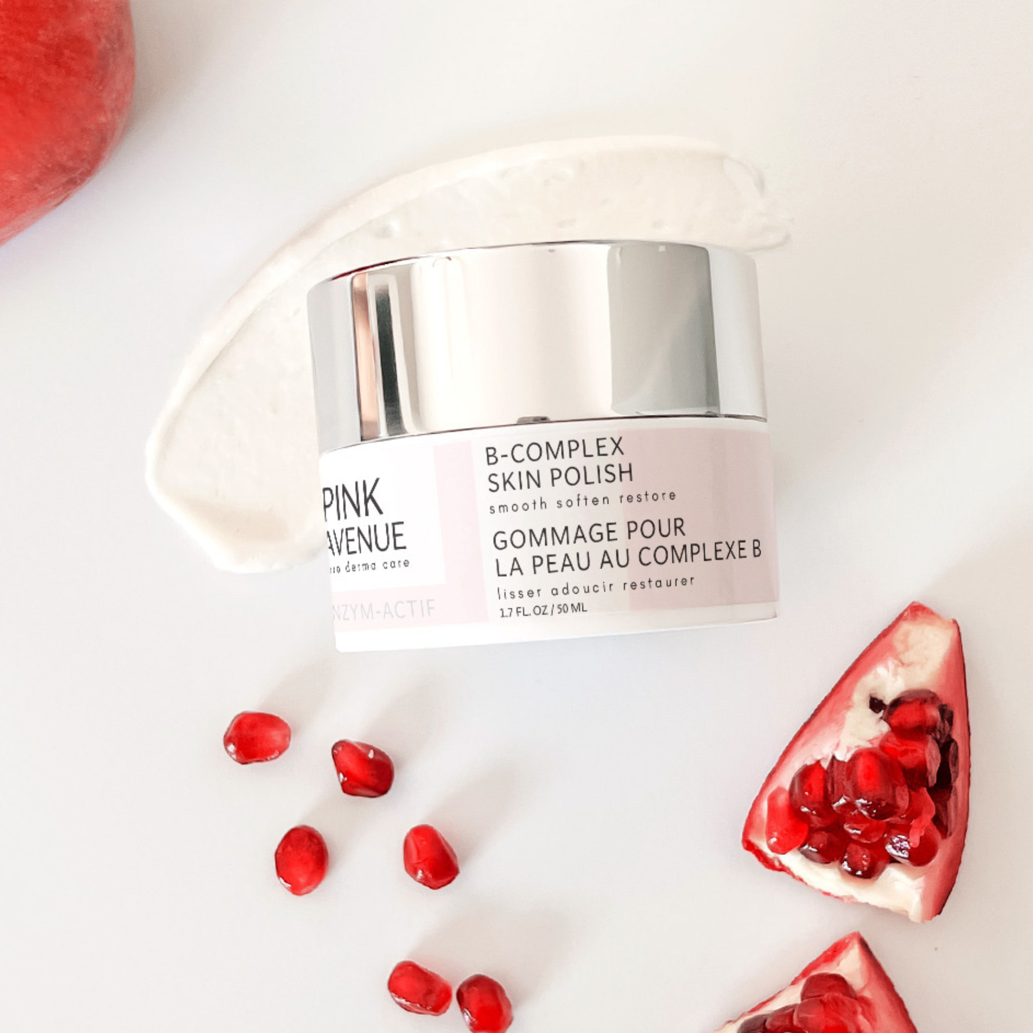 Pink Avenue B Complex Skin Polish Sproduct with pomegranate seeds on a white background