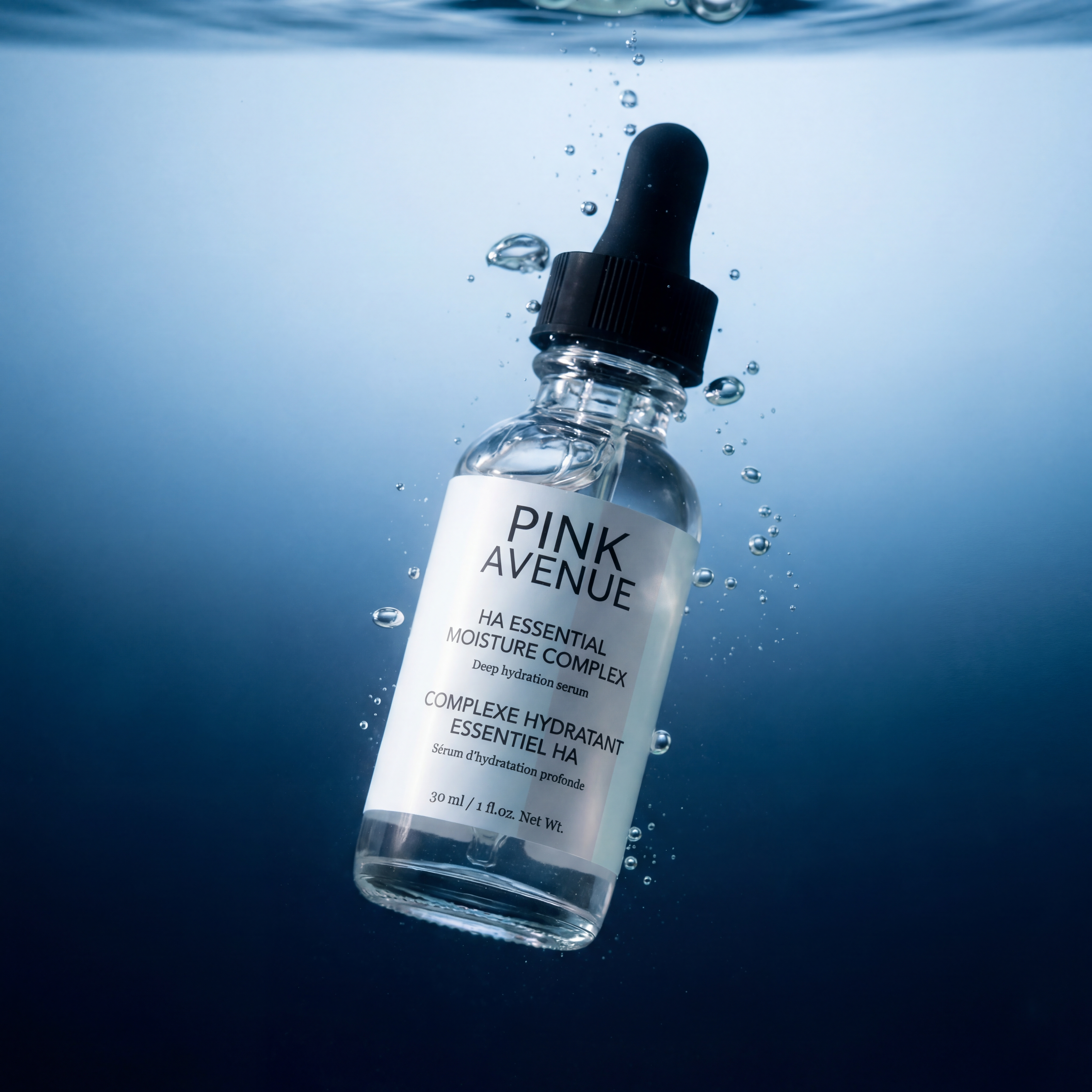 Chai serum Pink Avenue nổi lơ lửng dưới nước với những bong bóng khí.