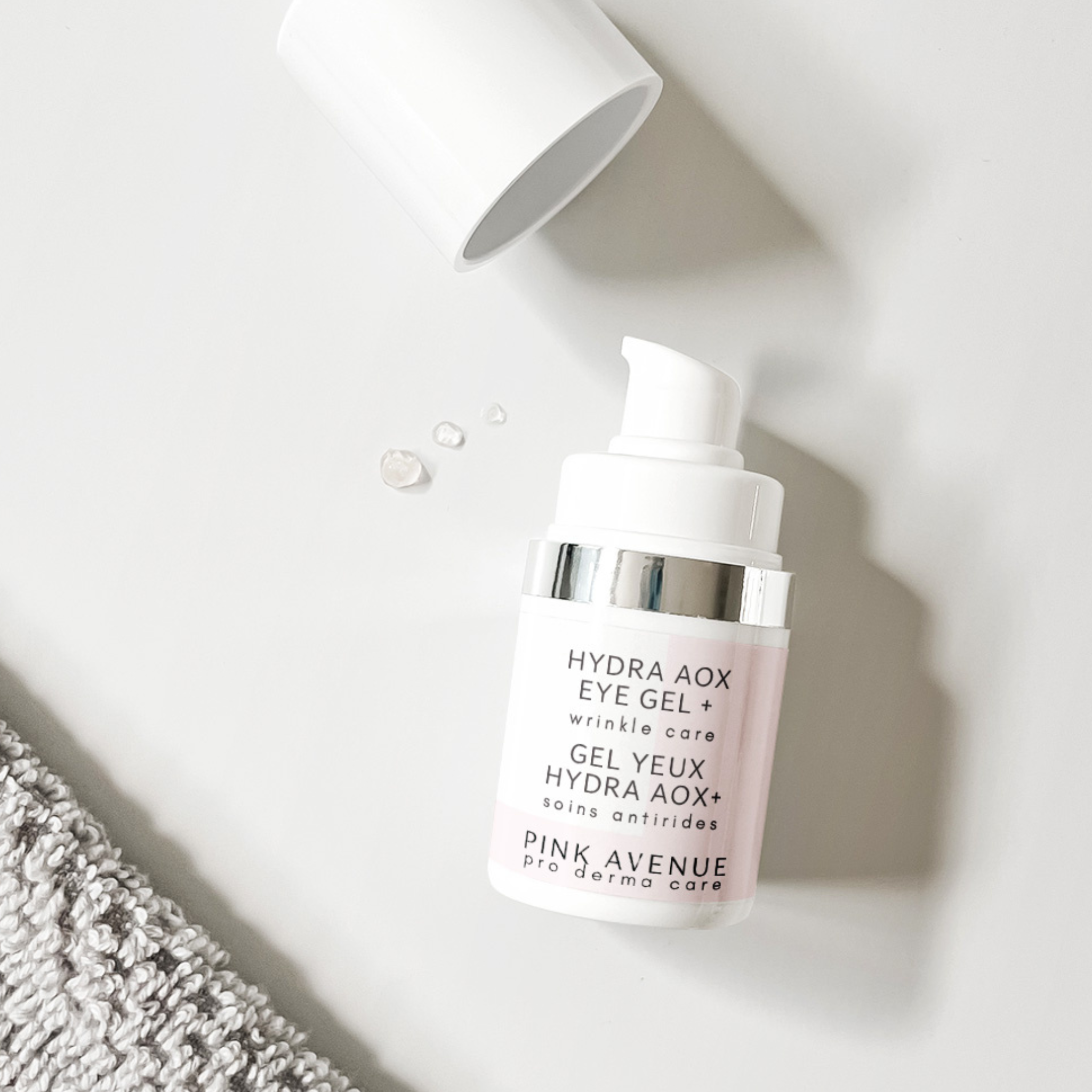 Pink bottle of Hydra AOX Eye Gel with a white background