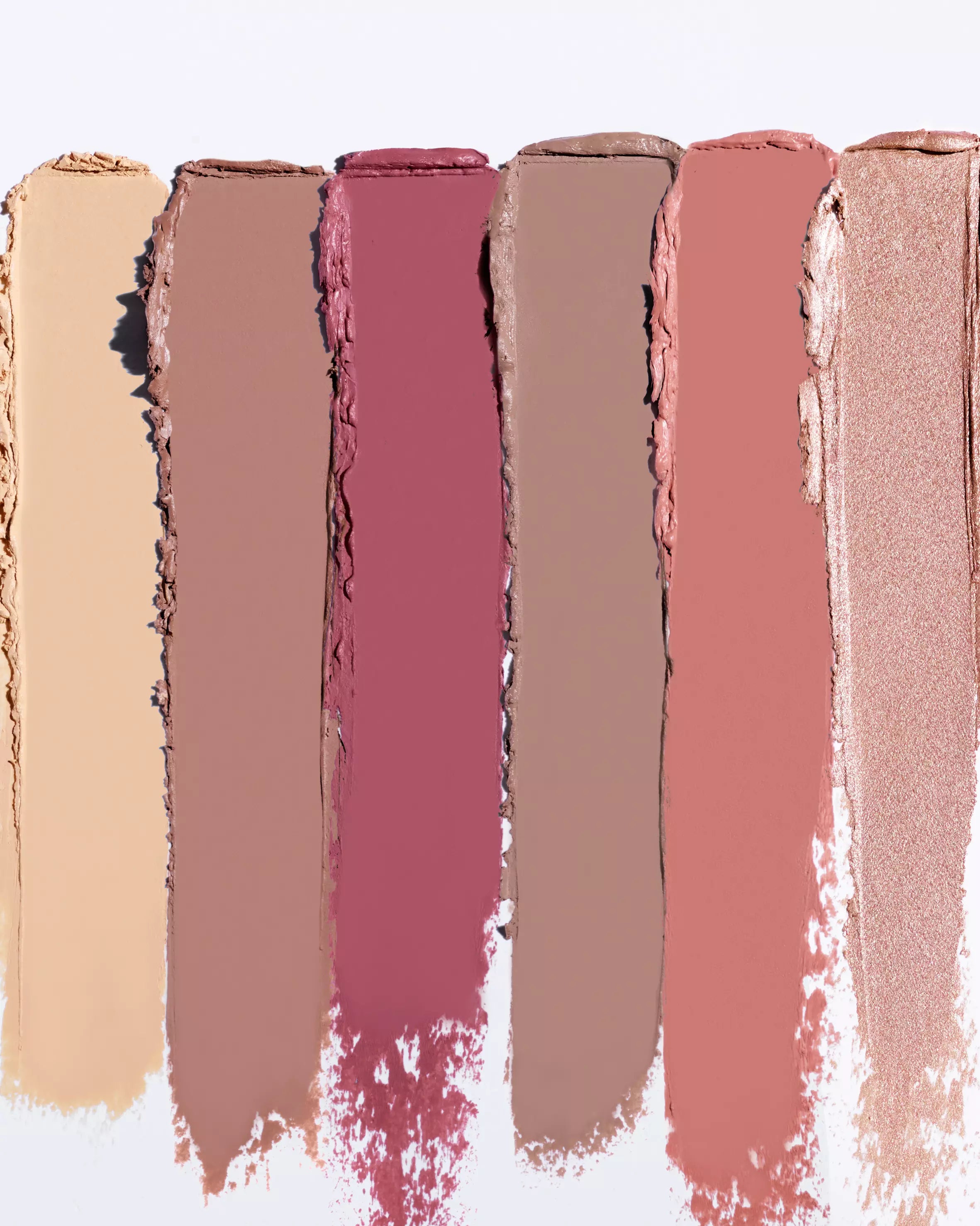 Nude and pink lipstick swatches on a white background