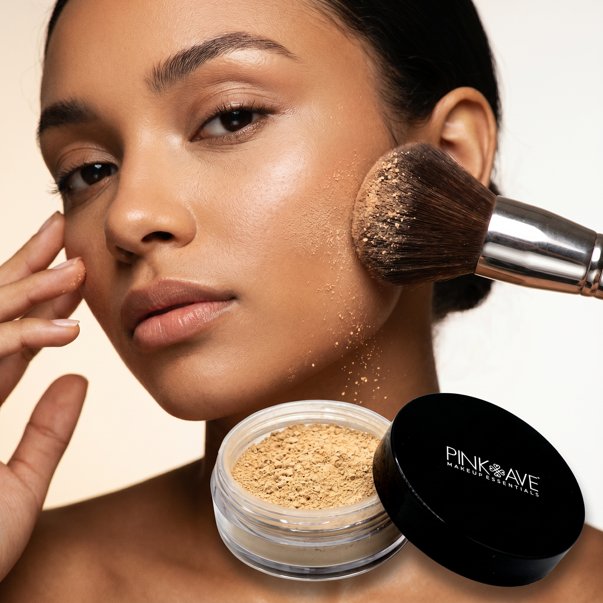 Woman applying makeup with a brush and pink eye product container on a beige background